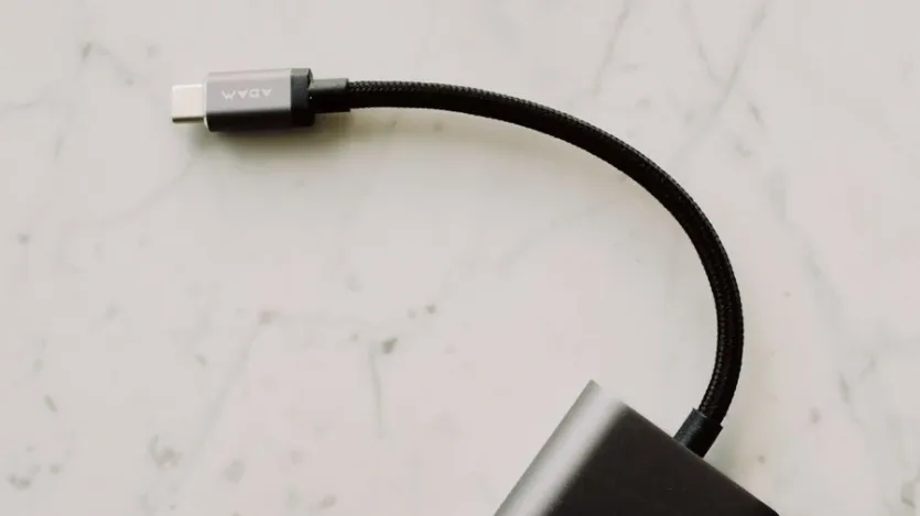 대리석 바닥 위에 놓인 검은색 USB-C 충전 케이블