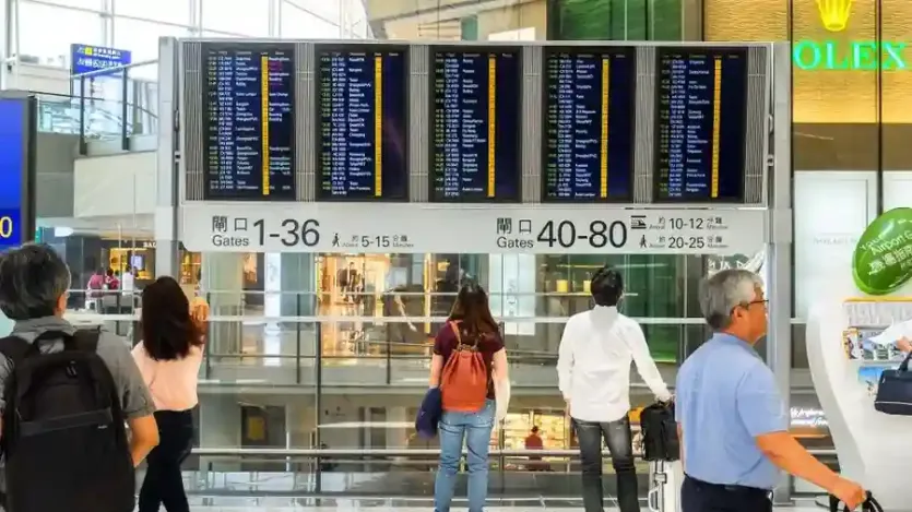 공항 출국장 전광판 앞의 여행객들