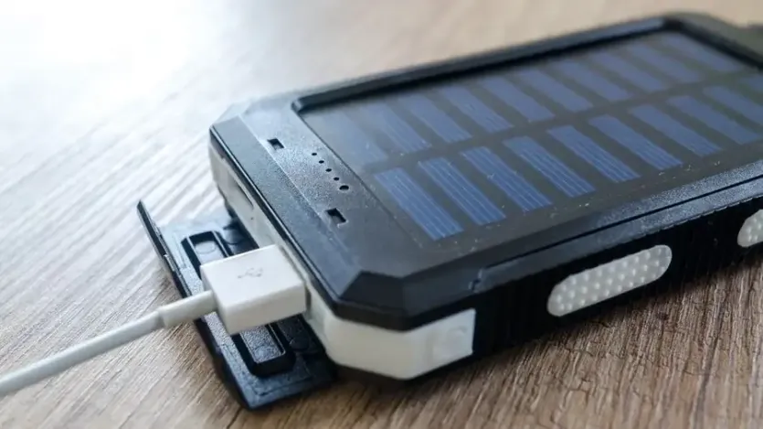 태양광 패널이 달린 휴대용 배터리에 USB 케이블을 꽂은 모습