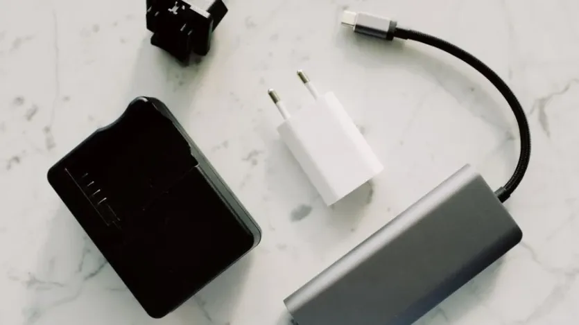 여러 개의 USB-C 충전 어댑터와 케이블이 책상 위에 놓여 있는 모습