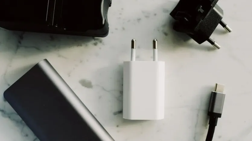 노트북 옆에 USB-C 충전 어댑터와 케이블이 놓여 있는 책상